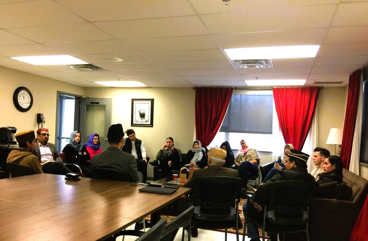 Students and faith group members meeting with mosque representatives during a group visit